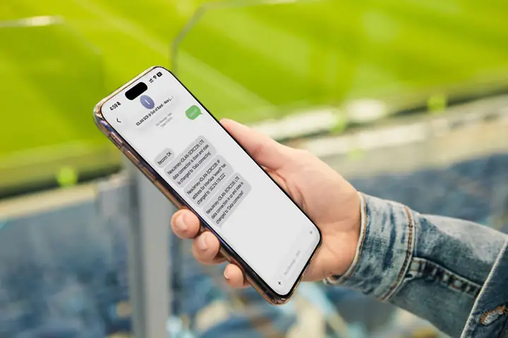 Mano Sosteniendo Un Teléfono Inteligente En Un Estadio Deportivo Enviando Mensajes De Texto A Iolan Scrc Para Habilitar Una Conexión Celular